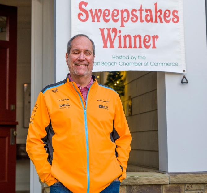 Jeff Moorad standing in front of a "Ring of Lights Sweepstakes Winner" banner.