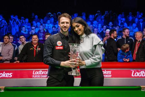 Judd Trump of England with his trophy and a woman.