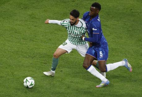 Isco and Benoit Badiashile vying for the ball during a soccer match.