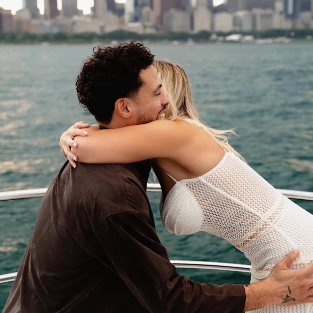Elle Brown and her fiancé embracing on a boat.