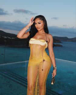 Woman in yellow crochet dress by the ocean.