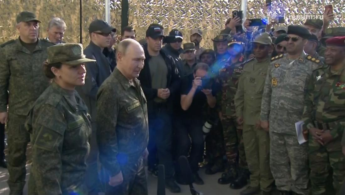 Vladimir Putin in military uniform at the Zapad-2025 drills, surrounded by other military personnel and observers.