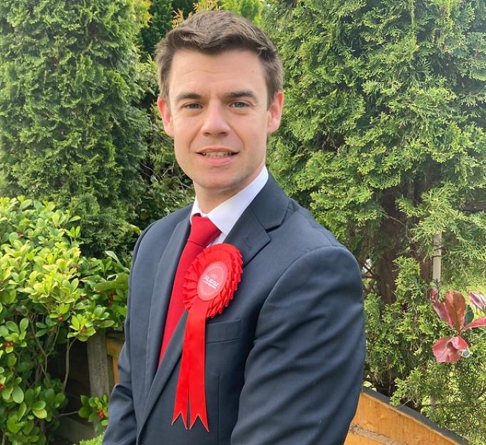 Phil Bricknell, the Labour candidate in Bolton West, wearing a red rosette.