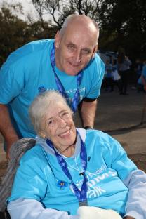 A woman in a wheelchair and a man in a blue Alzheimer's Society t-shirt at a Memory Walk.