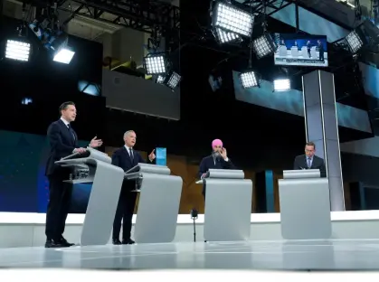 Four politicians at podiums during a debate.