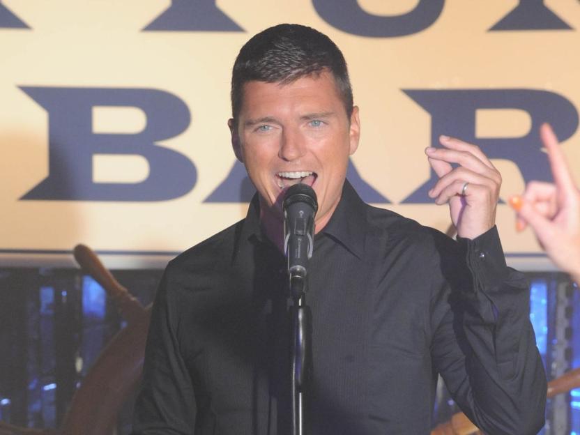 Asa Elliott singing into a microphone.