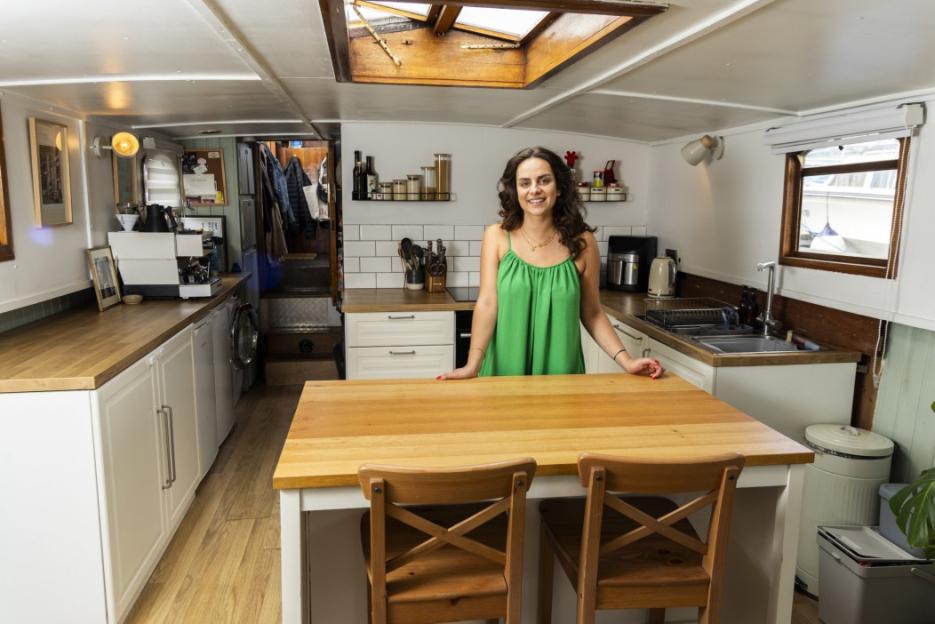 Woman standing in her houseboat kitchen.