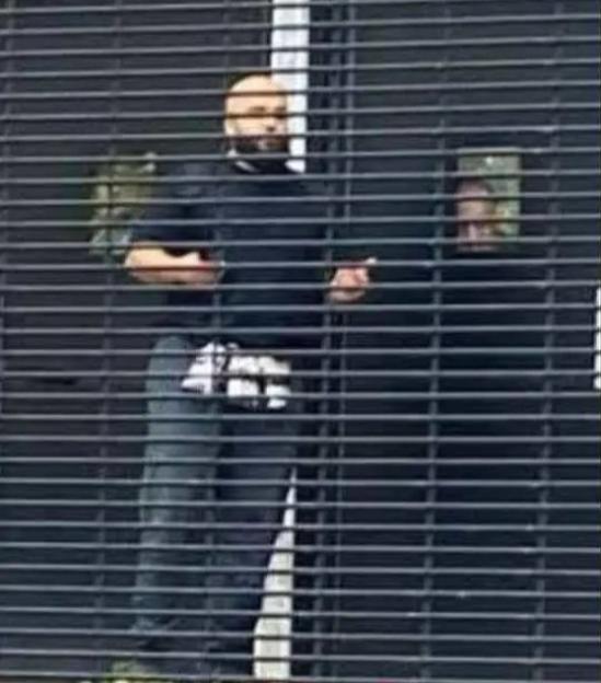 Man suspected of being a terrorist behind a shuttered gate.