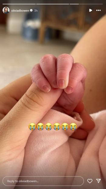 Newborn's hand grasping an adult's finger.
