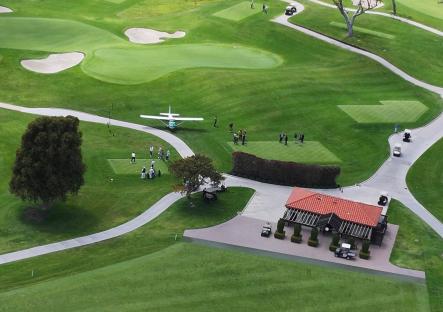 Aerial view of a private plane making an emergency landing on a golf course.