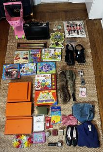 Collection of items found dumpster diving, including toys, games, clothing, and accessories.