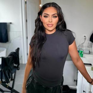 Woman with long dark hair wearing a black shirt and pants.