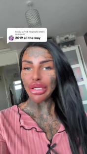 Woman with extensive face tattoos and lip fillers.