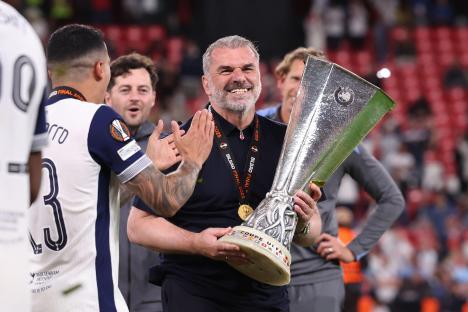 Ange Postecoglou, Tottenham Hotspur coach, holding the UEFA Europa League trophy.
