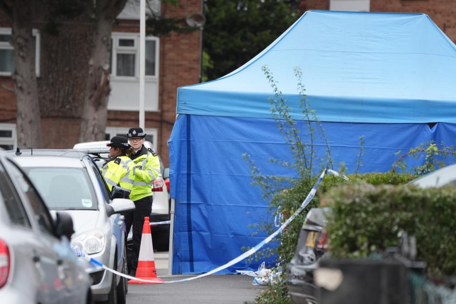Police officers and a blue tent at a crime scene in Uxbridge.