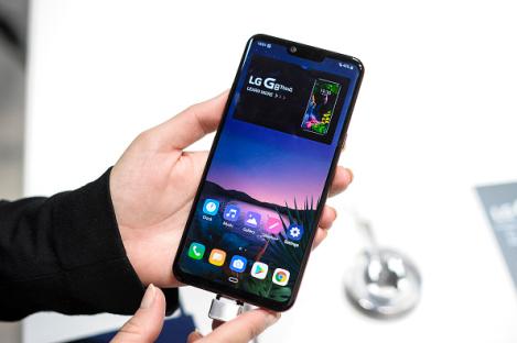 Person holding and displaying an LG G8 ThinQ smartphone.