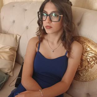 Teenage girl in blue dress and glasses.