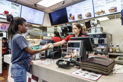 A McDonald's cashier handing change to a customer.