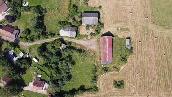 Aerial view of a French village with farmhouses and surrounding fields.