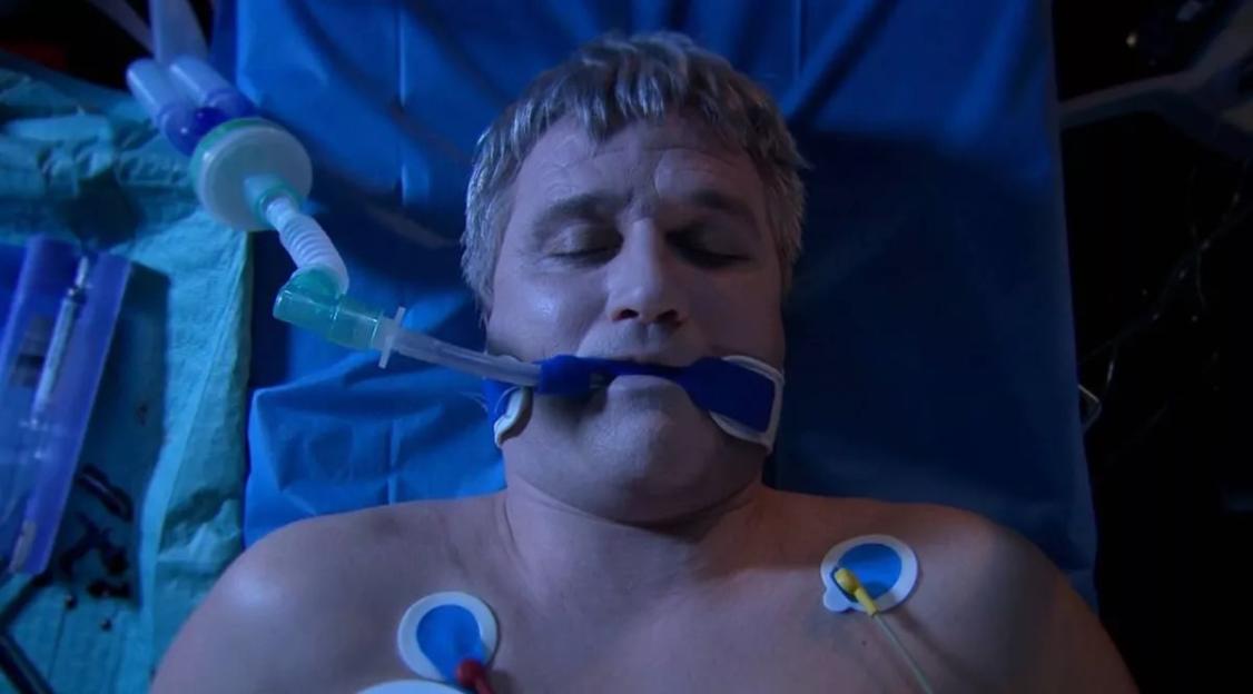 Joe Tate sedated in a hospital bed.