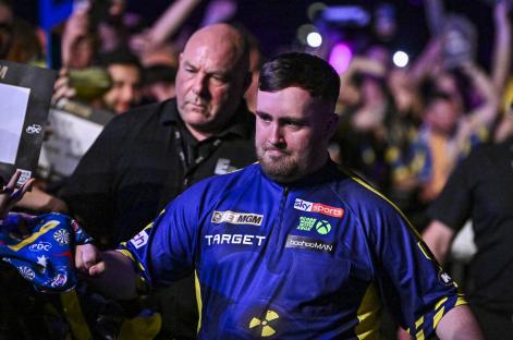 Luke Littler greets fans before a darts match.