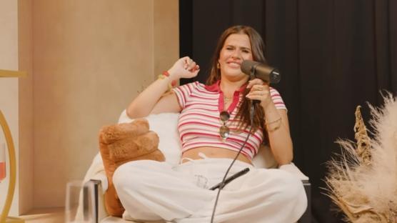 Woman sitting and smiling while holding a microphone.