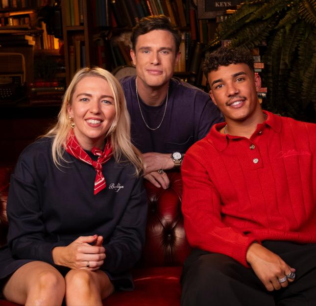 Maddy Smedley, Ed Gamble, and Freddie Fraser sitting on a red leather couch.
