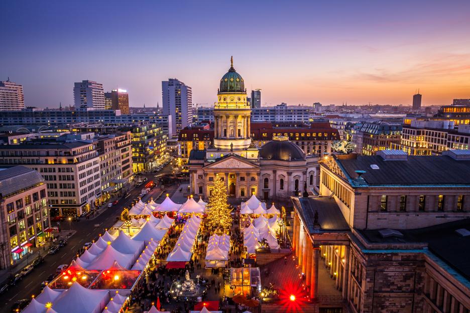 Panoramic view of Gendarmenmarkt Christmas market in Berlin, Germany at dusk.