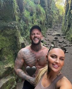 Couple posing for a photo on a mossy path.
