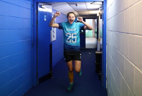 A jubilant soccer player celebrates a victory in a tunnel.