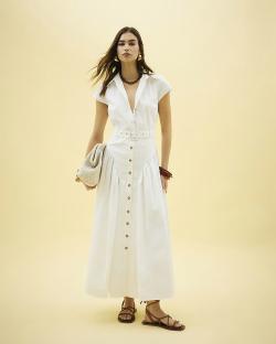 Woman in a white belted midi shirt dress.