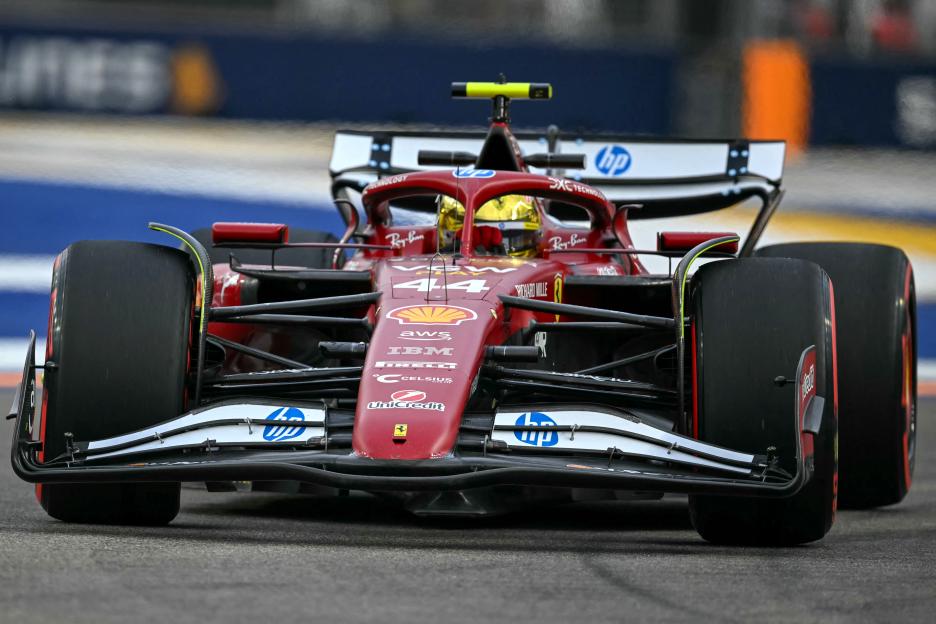 Ferrari's British driver Lewis Hamilton driving a red Formula One car at the Marina Bay Street Circuit in Singapore.