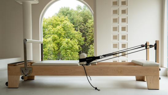 Pilates reformer in a bright room.