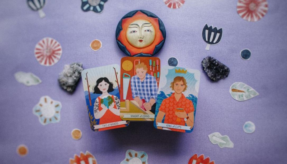 Three tarot cards; Two of Wands, Knight of Coins, and King of Cups, arranged with crystals and decorative elements on a purple background.