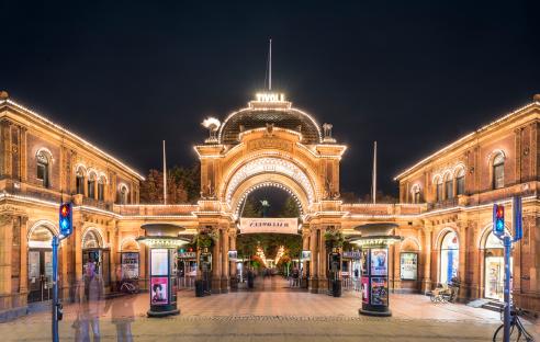 Illuminated entrance to Tivoli Gardens in Copenhagen at night.