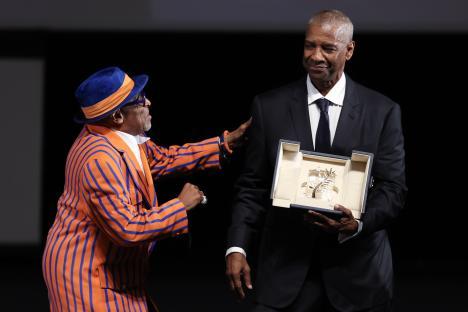 Denzel Washington receives the Honorary Palme d'Or from Spike Lee at the Cannes Film Festival.