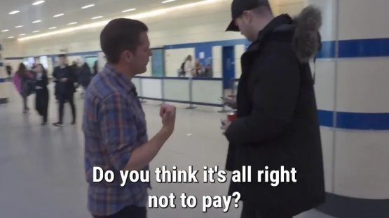 Two men in a transit station; one asks,