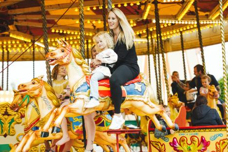 Woman and child on a carousel horse.