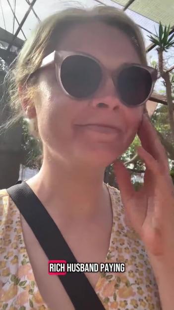 Woman wearing sunglasses outdoors with text overlay "RICH HUSBAND PAYING".