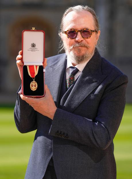 Sir Gary Oldman holding his Knight Bachelor medal at Windsor Castle.