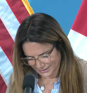 Woman with glasses at a press conference.