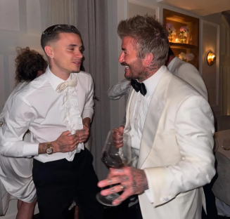 Two men in formal wear laughing together.