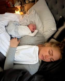 Mother and baby sleeping together in bed.