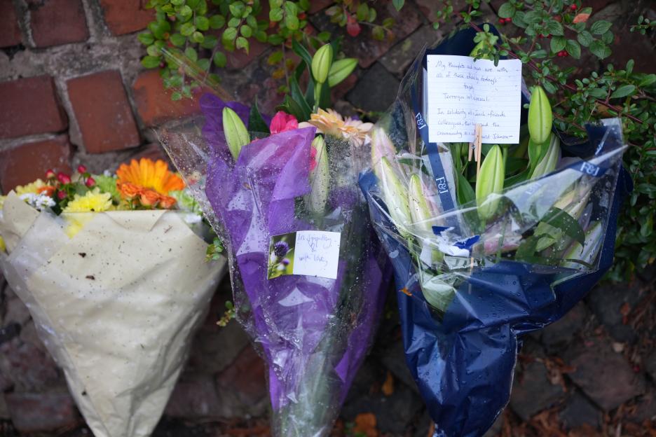 Three floral tributes with handwritten notes in Manchester, England.