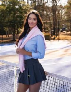 Woman in tennis attire on a tennis court.