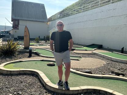 Man standing on a mini golf course.