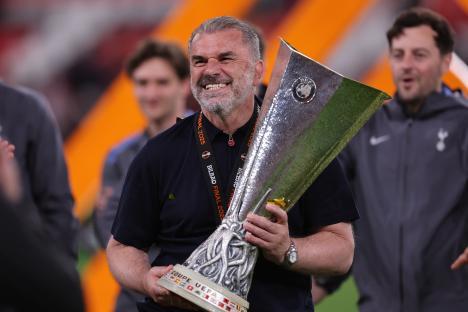 Ange Postecoglou holding the UEFA Europa League trophy.