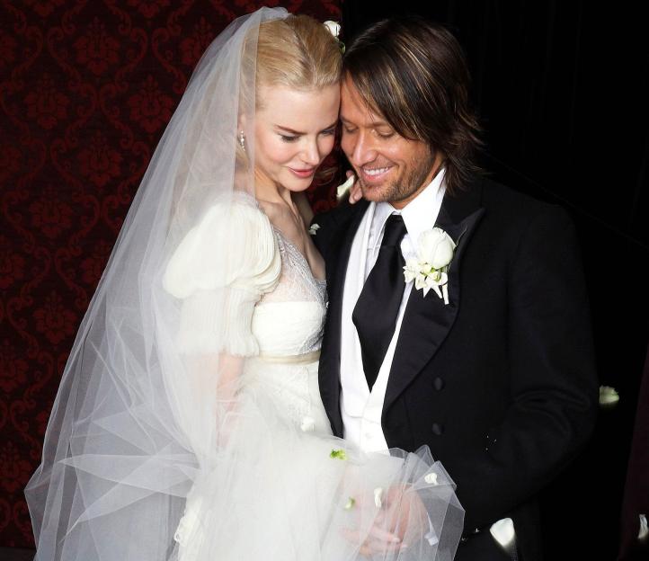 Nicole Kidman in a white wedding gown and veil with Keith Urban in a tuxedo.