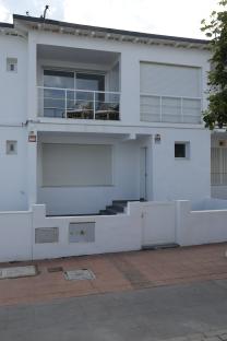 White two-story house with a balcony.