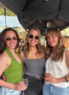 Three women enjoying drinks outdoors.